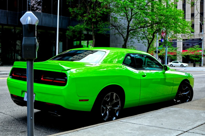 bright green dodge car sitting on the side of a street