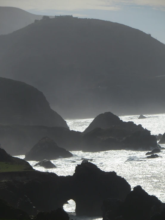 the lone bird is on the rocks near the water