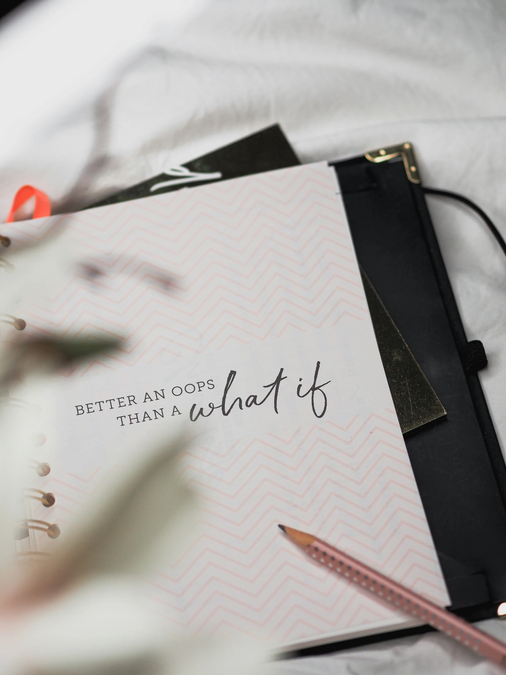 a book on top of a pillow next to a pink flower