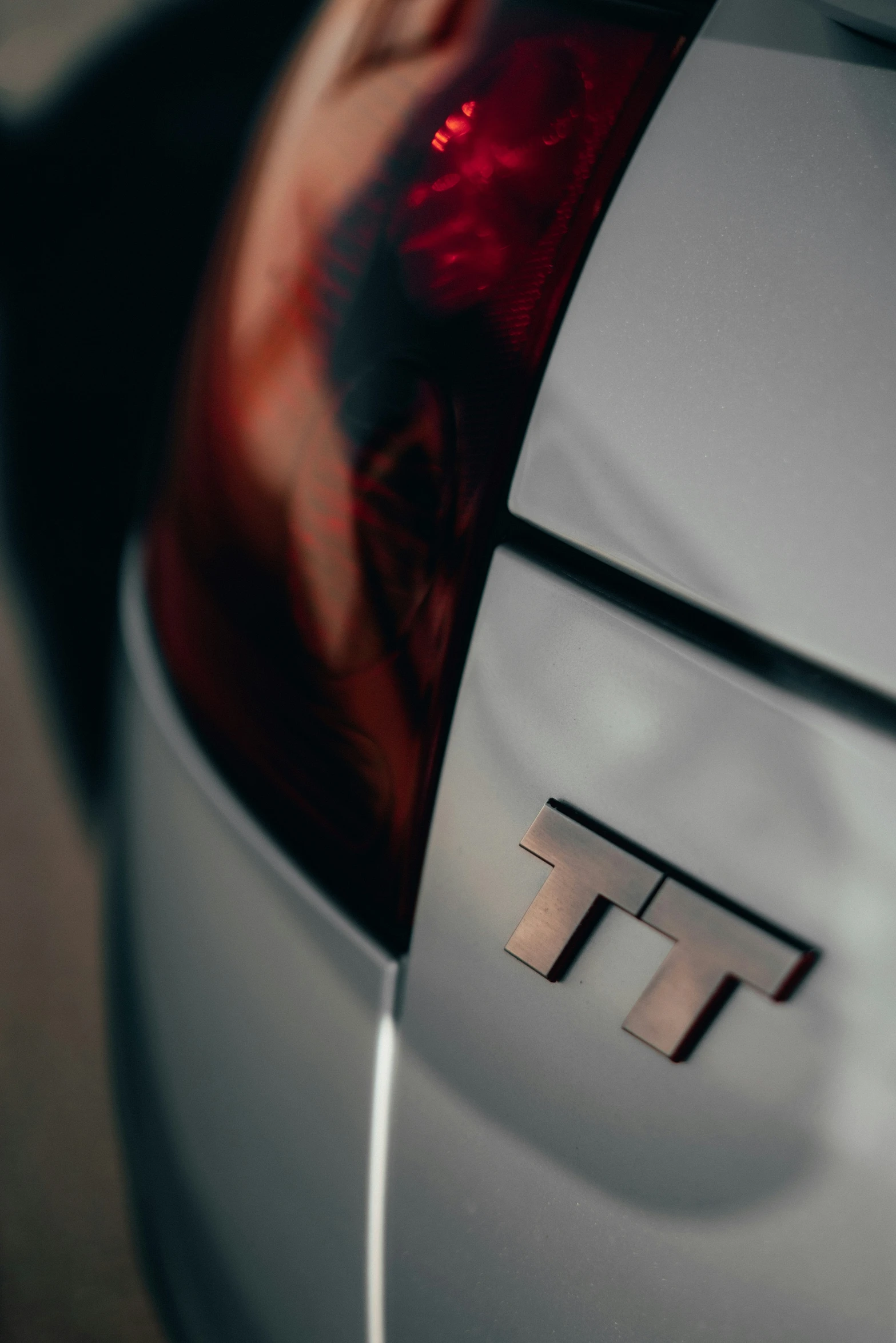 an image of a car tail light with a reflection of the car