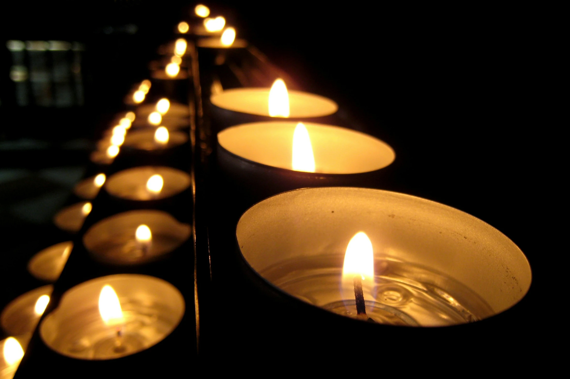 small candles lit in front of a wall