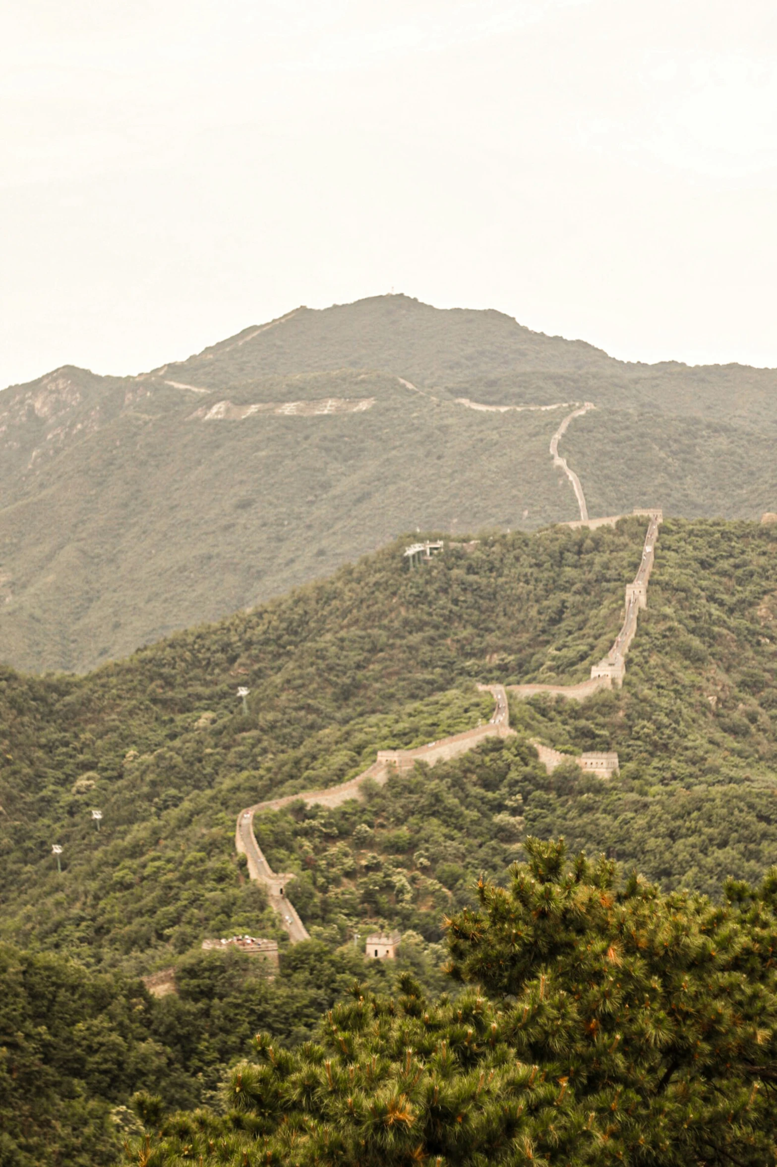 winding dirt road in the green mountains during daytime