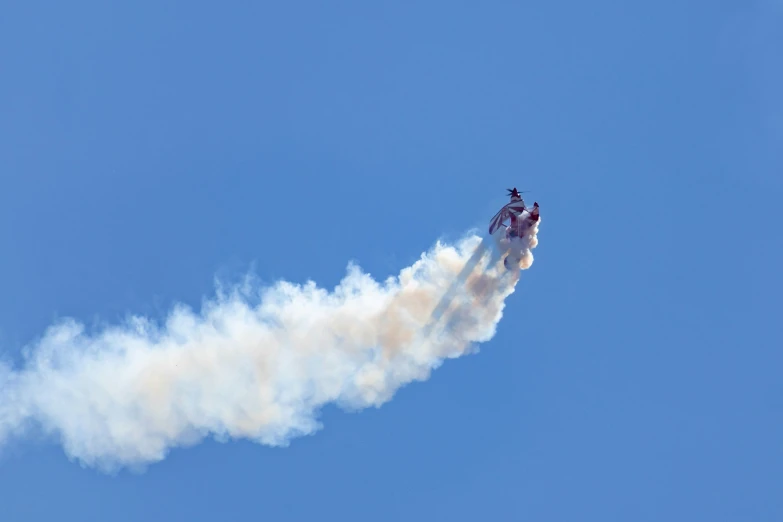 a sky view of a stunt plane flying through the air