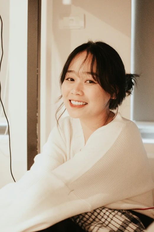 an asian woman in a white coat smiling