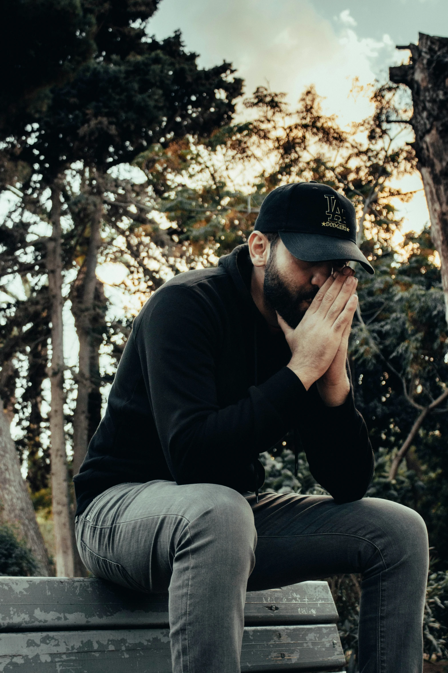 a bearded man sitting on a park bench