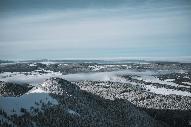 there are mountains with low lying clouds in the sky