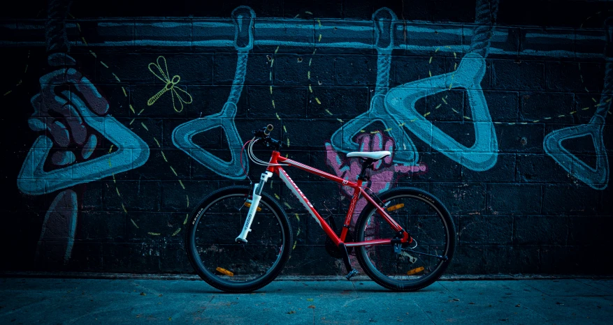 a bike sitting against a building with graffiti on it