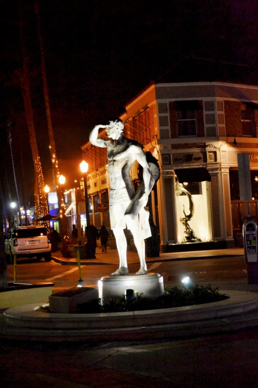 a statue standing on the edge of the road with a man standing on it