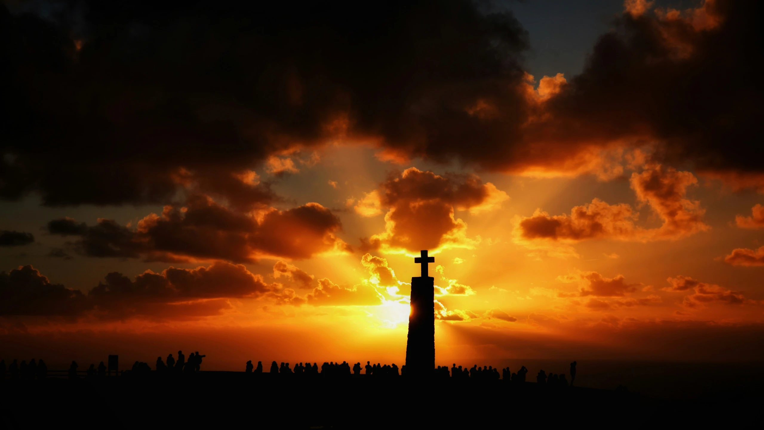 the silhouette of a very tall, steeple with a cross at the top