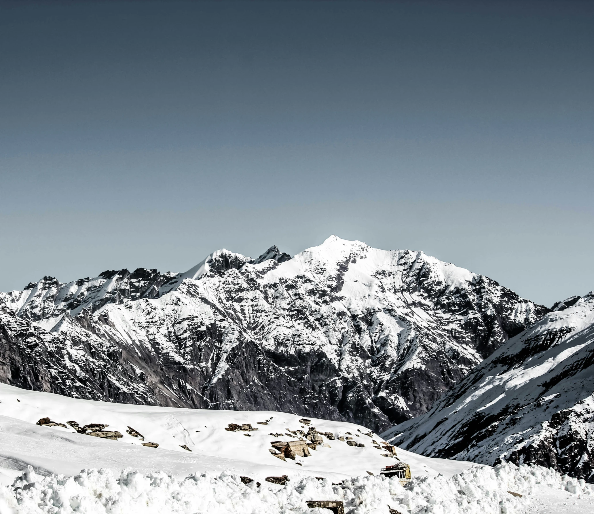 a snowy mountain that has a person on top of it