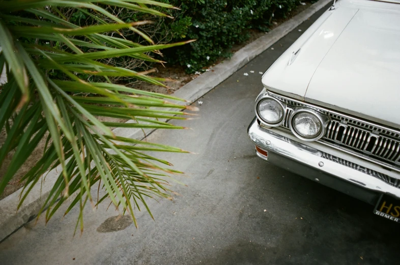 there is an old ford automobile parked on the sidewalk