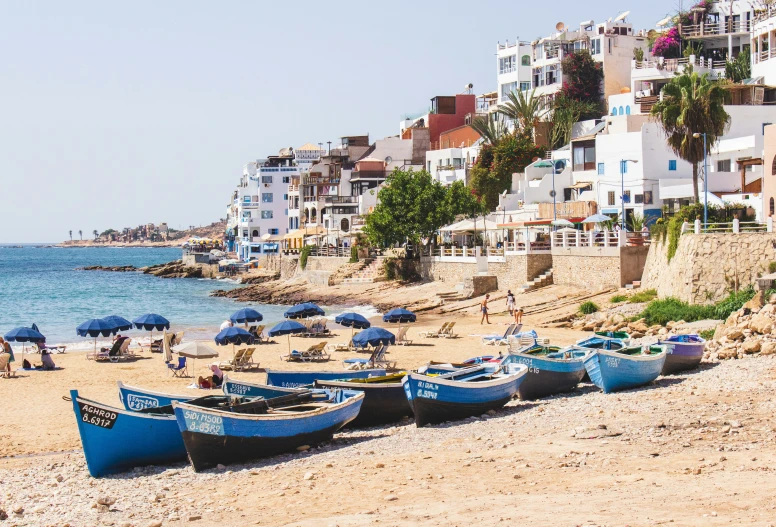 people are on the beach with their boats