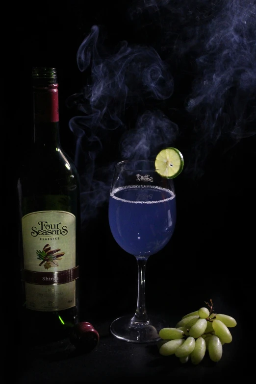 a glass and bottle on a table with smoke