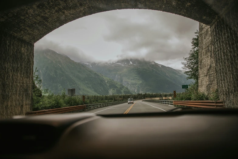 cars driving under an arch on a highway