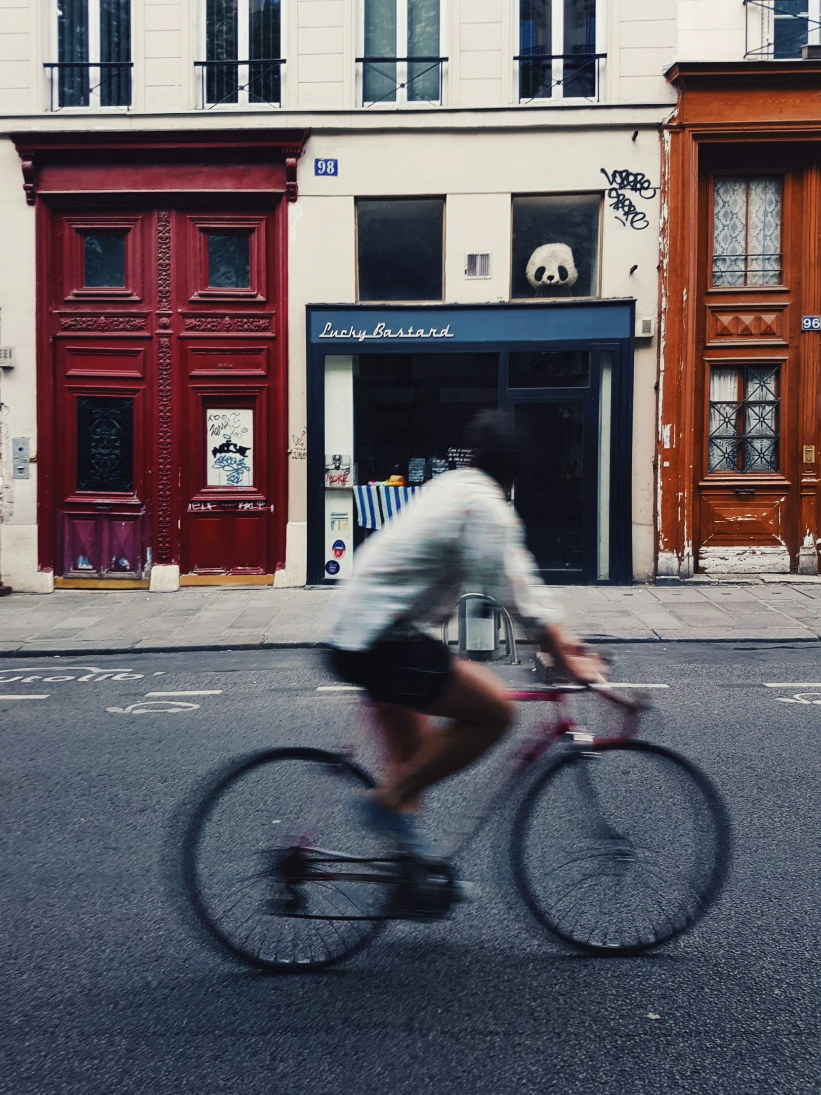 man riding bicycle in front of store on empty street