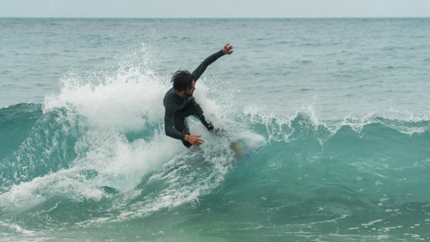 the man is riding a wave on his surfboard