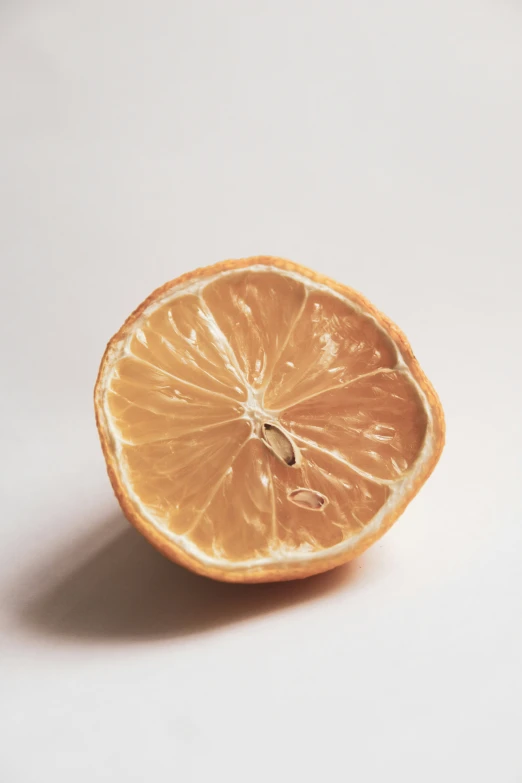 a whole orange slice lying on top of a white surface