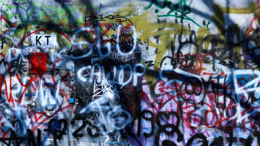 a wall full of lots of graffiti that says it is out