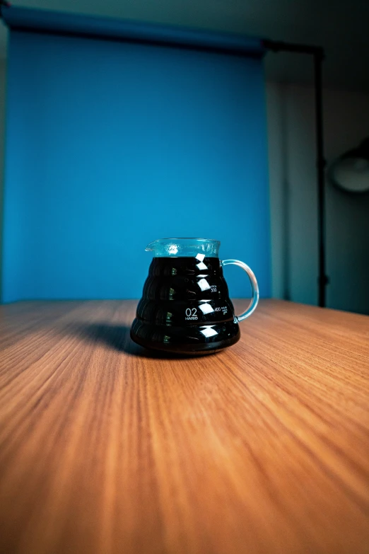 a small black glass device sitting on a wooden table