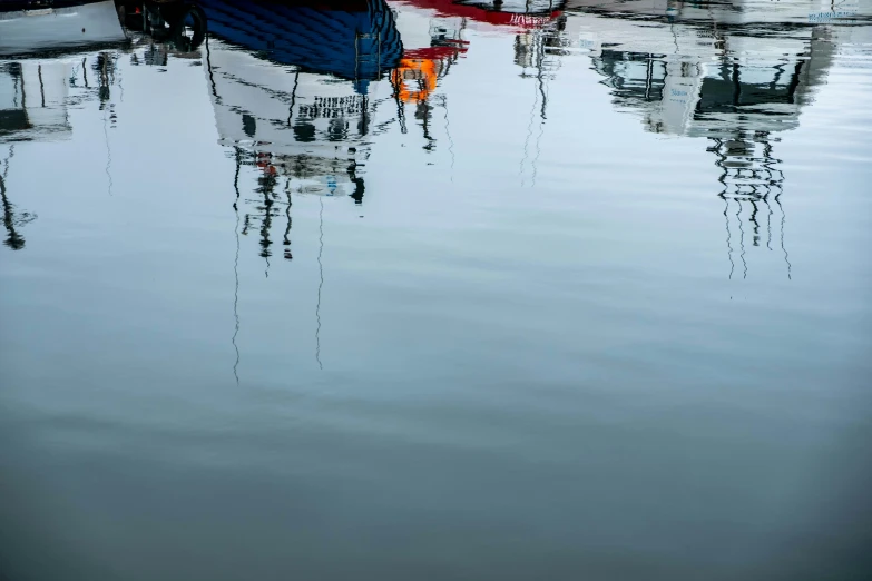 some boats are sitting on the water, with some one in front of them