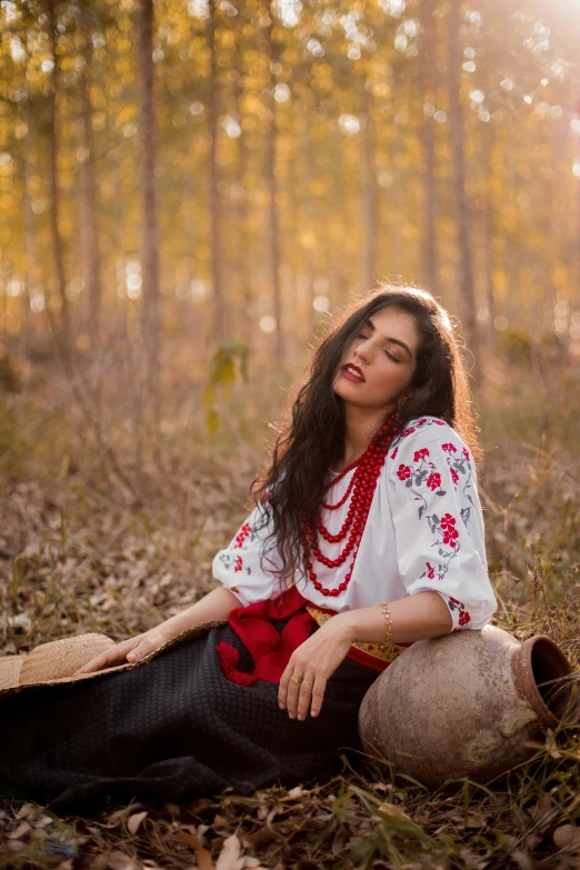 a woman in a white shirt is sitting on the ground