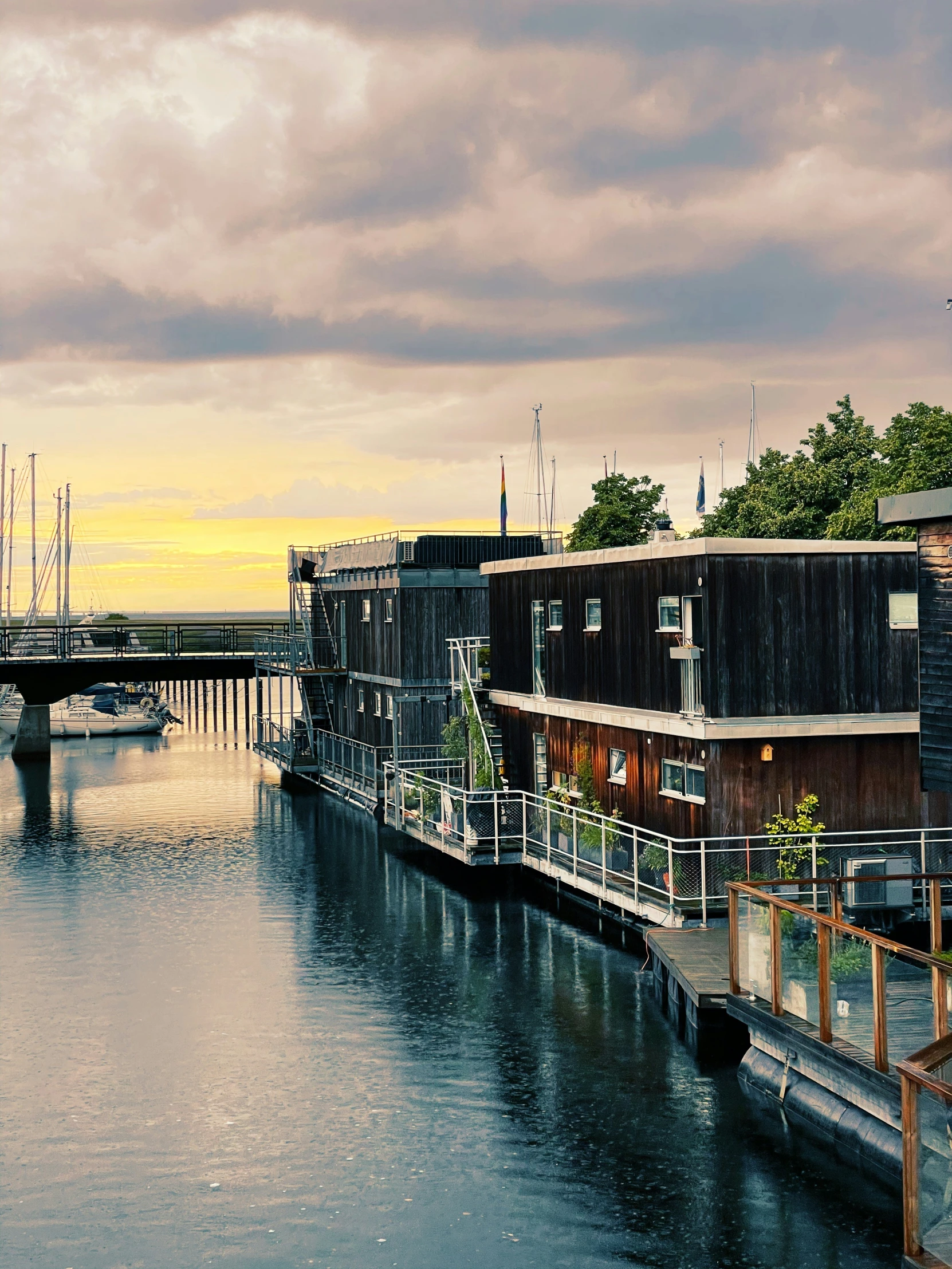 a waterway next to houses with boats docked and bridge in the background