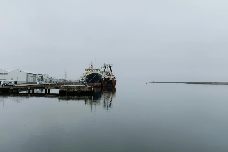 a small ship floating next to a long pier