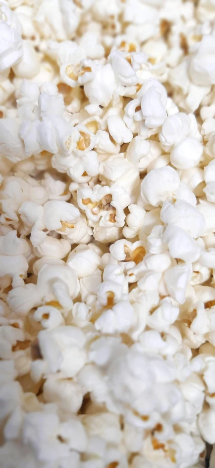 an overhead view of a bowl of popcorn with the kernels sprinkled over it