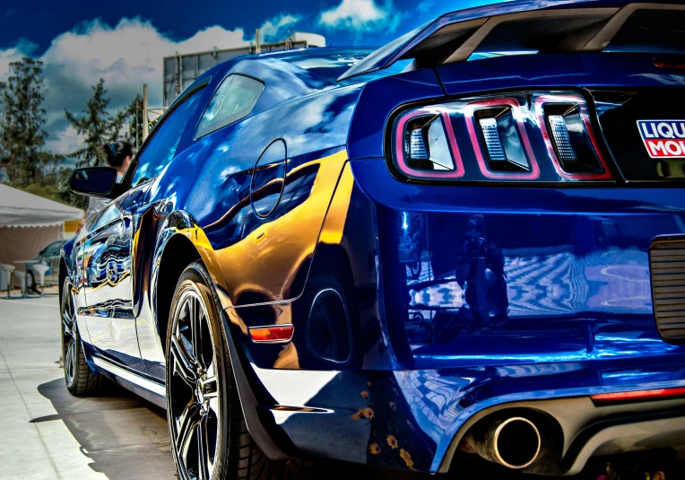 the rear end of a blue, yellow and black car