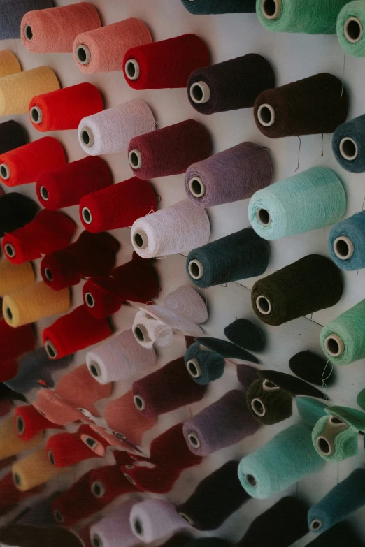 a variety of spools of colorful thread with different colors on them
