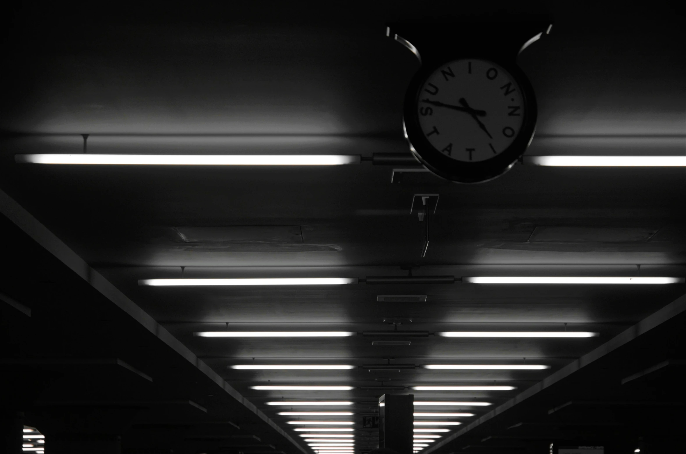 an empty train car with a large clock hanging on the ceiling