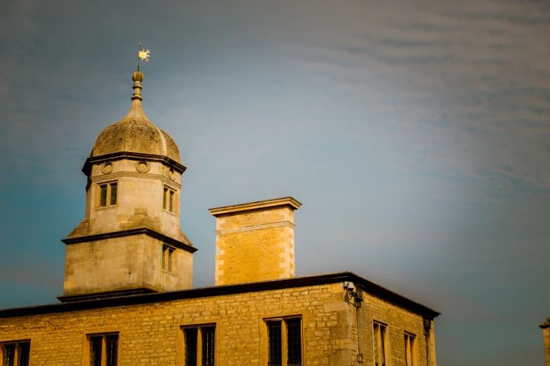 an old brick building with two towers and a cross on top