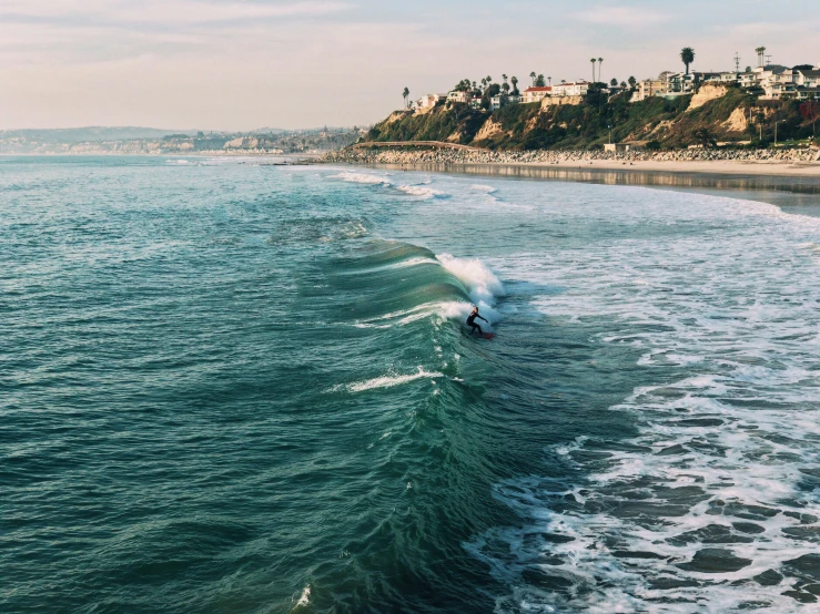 a surfer rides a big wave at the edge of the ocean