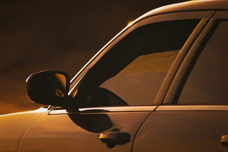 side view mirror on the back of a car at sunset