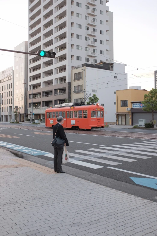 two people wait to cross a street at an intersection