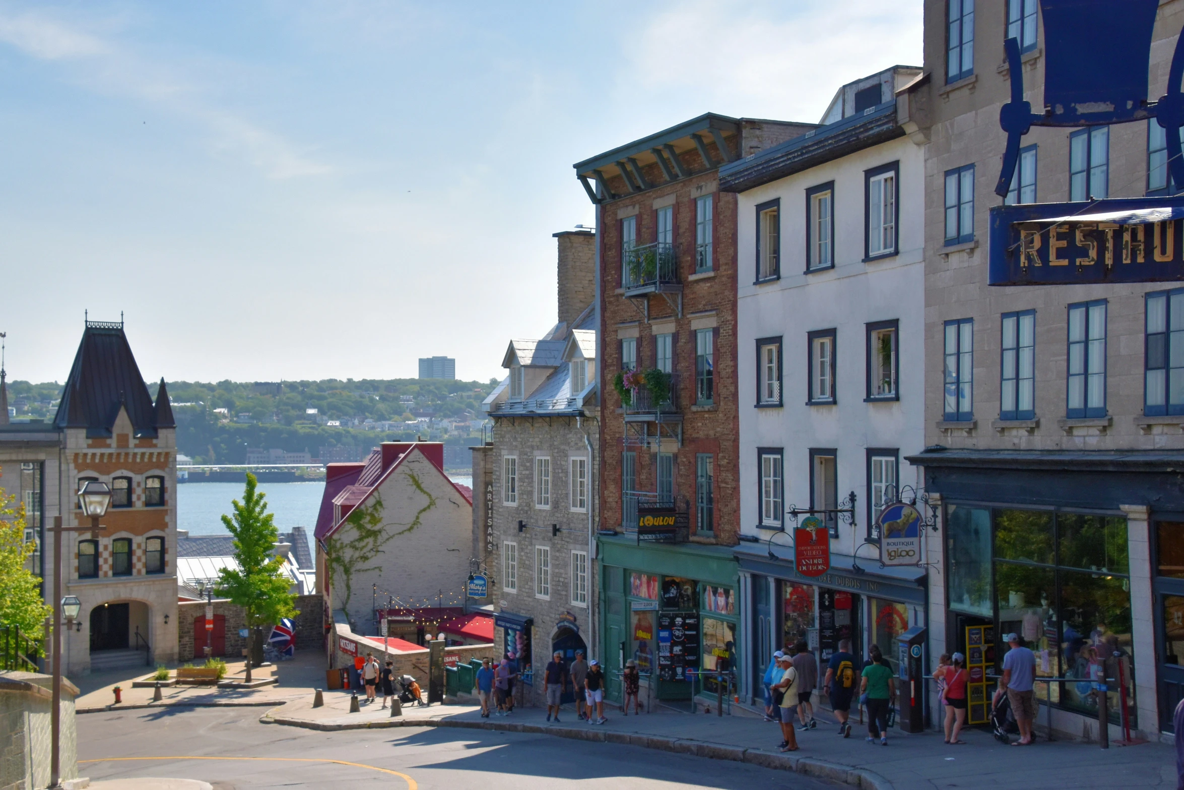 street view of shops and buildings with water in background