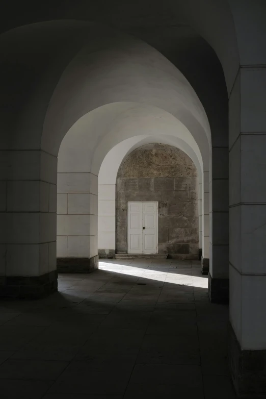 an arched stone entrance leads to a light