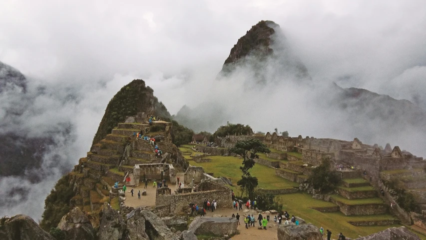people are standing on the top of an ancient mountain