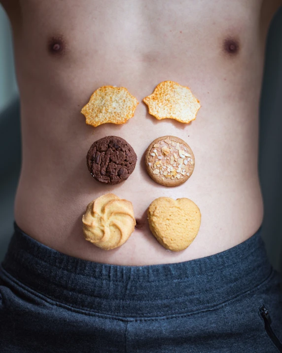 a woman's stomach is covered with cookies, peanut er, and cookies