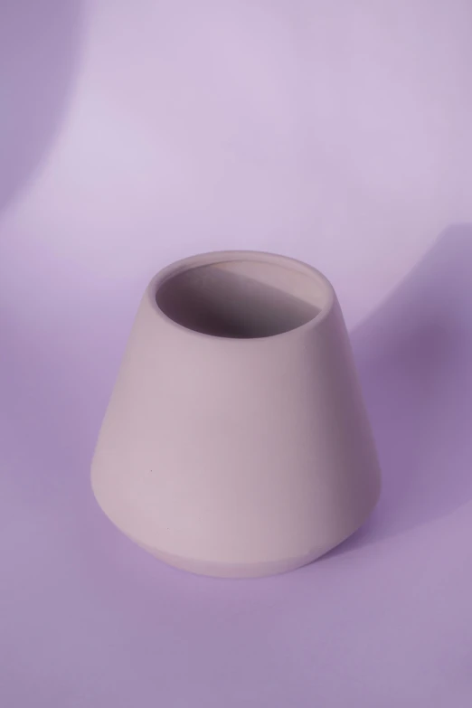 a white clay vase sitting on top of a table