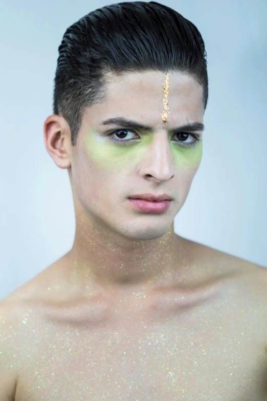 a close up of a man's face with gold jewelry