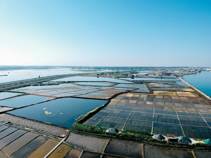 a large greenhouse field with water surrounding it