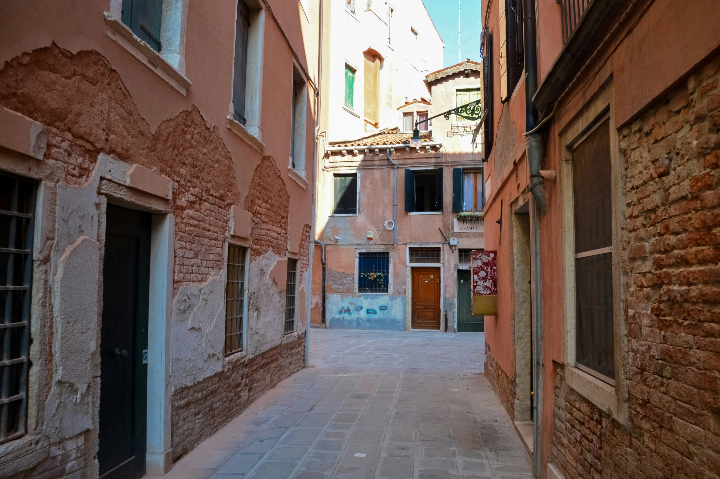 narrow streets of several brick and stucco buildings