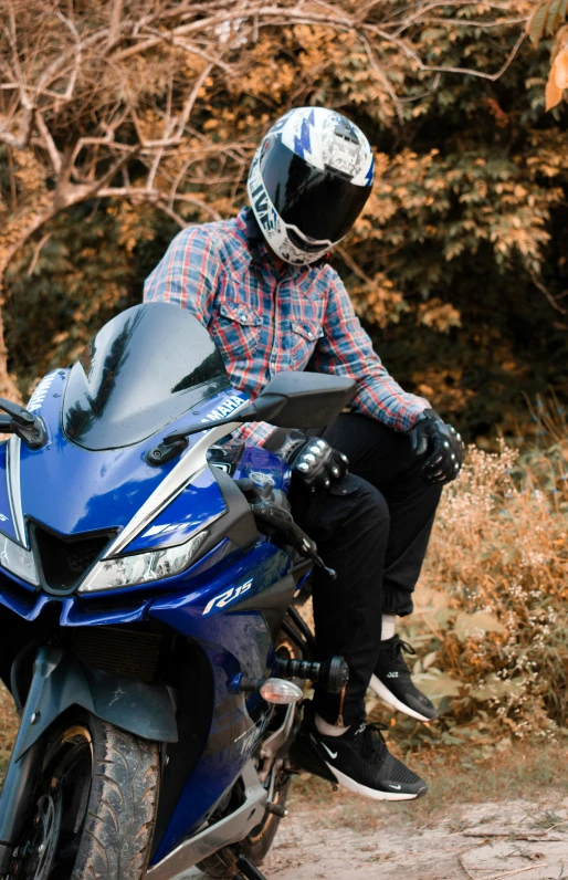 the motorcyclist wears a helmet as he sits on his bike