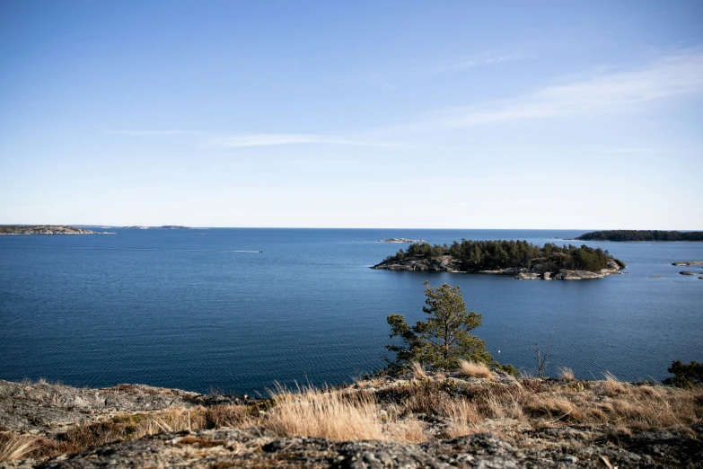 an island that looks like a tiny island with a few boats floating in the ocean