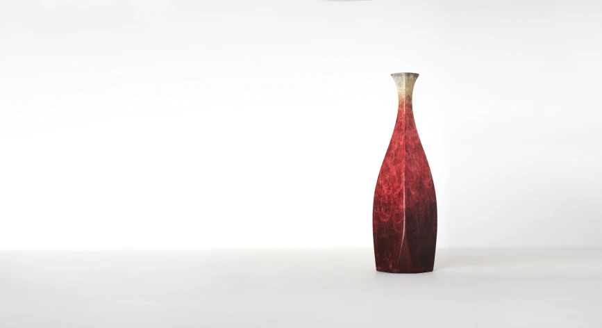 a long red vase with a gold point on top