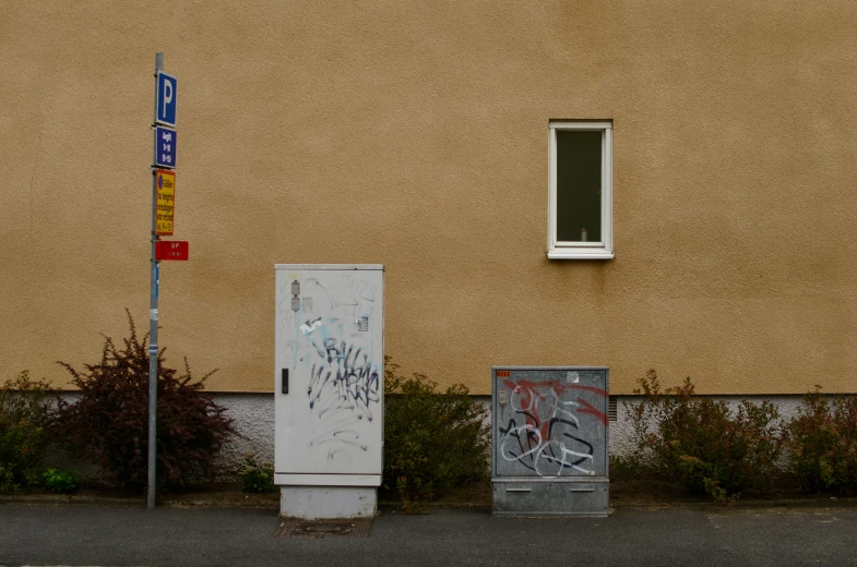 two white refrigerators covered in graffiti next to a building