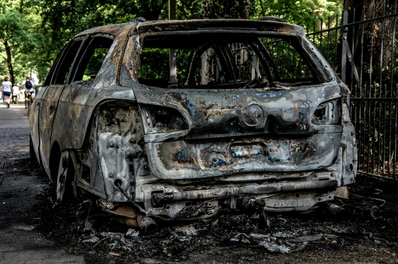 there is a burnt, rusty car that appears to have been parked