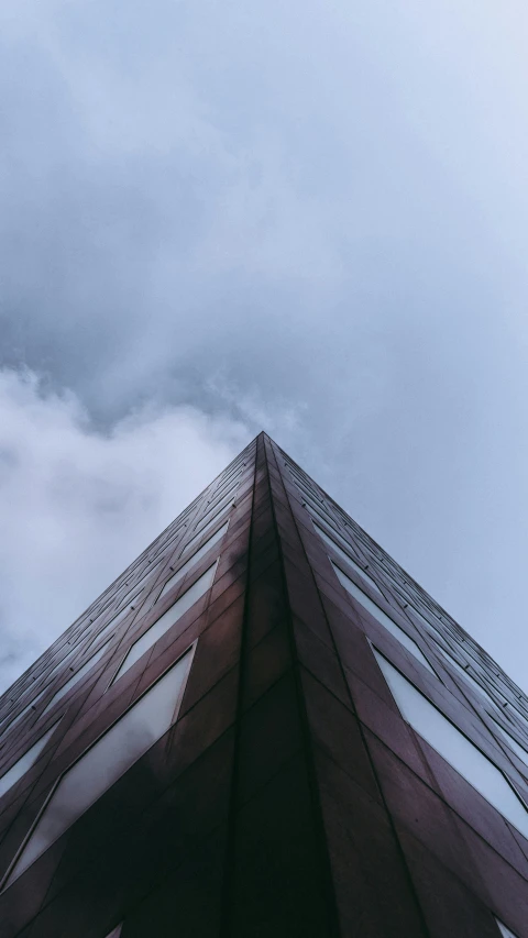 a tall glass building on a cloudy day