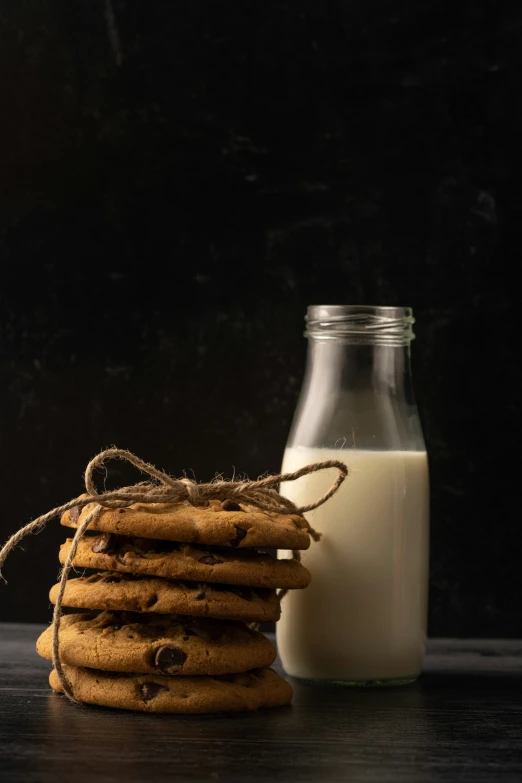 a bottle and a glass of milk next to cookies